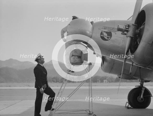Plant quarantine inspectors examining plane at the Glendale Airport, California, 1937. Creator: Dorothea Lange.