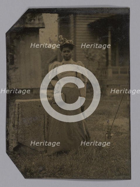 Tintype of a woman wearing a dress with hat and bag, 1890s. Creator: Unknown.