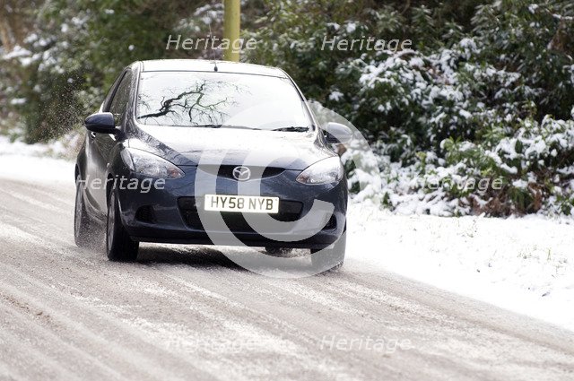 2009 Mazda 2 driving on snowy road Artist: Unknown.