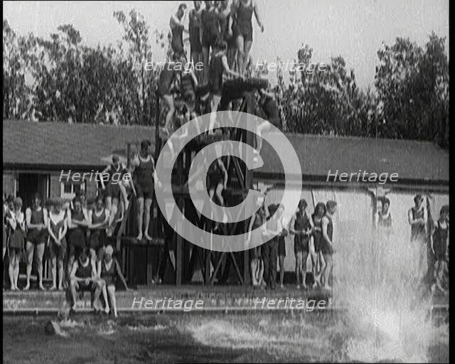 British People Jumping from Various Tiers of Diving Boards at the Chiswick Open Air Baths, 1920. Creator: British Pathe Ltd.