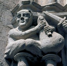 Detail of a capital representing a bagpiper, in the cloister of the Monastery of Santes Creus, ma…