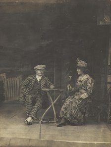 Two sailors, one in drag, sit on stage at a table, in front of very detailed scenery (1910-1919?). Creator: Unknown.