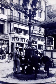 The fountain of Canaletas at the beginning of Las Ramblas, behind the iconic restaurants Canaleta…