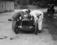 Mechanics working on Leon Cushman's Austin 7 racer for a speed record attempt, Brooklands, 1931. Artist: Bill Brunell.