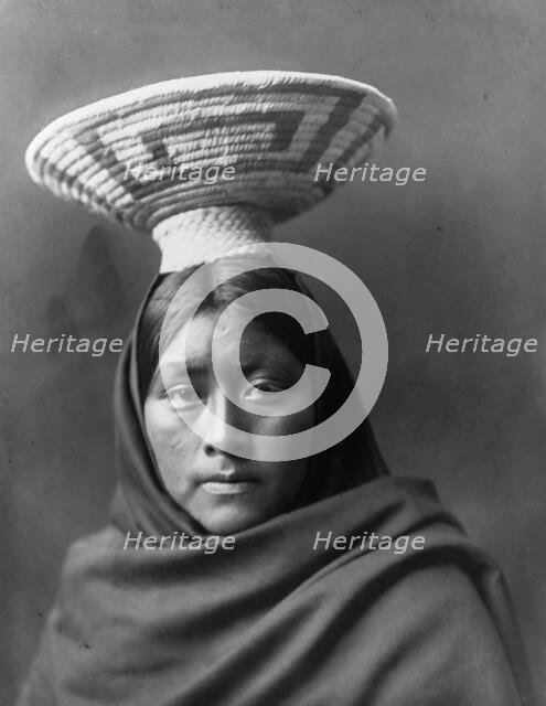 Papago Indian, Luzi, head-and-shoulders portrait, facing front, with a basket tray on her head,c1907 Creator: Edward Sheriff Curtis.