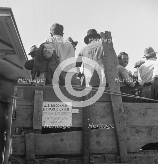 Labor contractor's truck with gang of pea pickers pulled up for gas, Westley, California, 1939. Creator: Dorothea Lange.