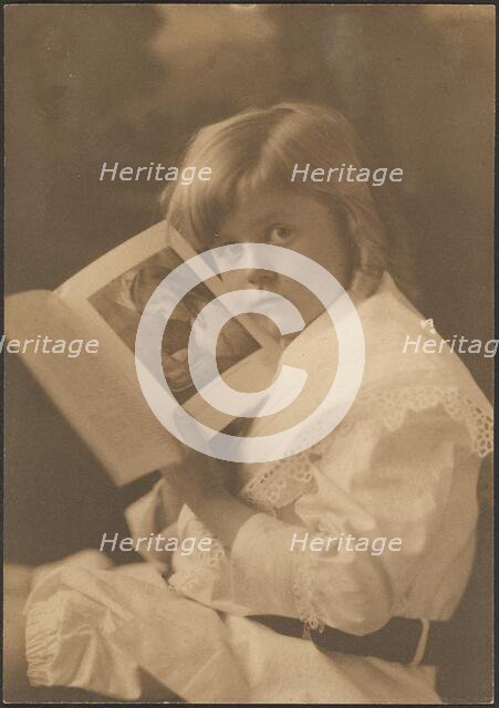 Portrait of Child Holding Book Open to Like Illustration, 1907-1943. Creator: Louis Fleckenstein.