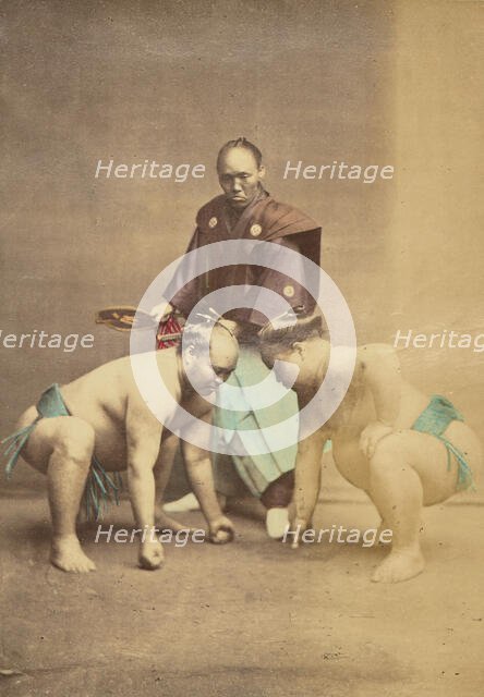 Two Japanese sumo wrestlers posed with referee, 1868-1880. Creator: Felice Beato.