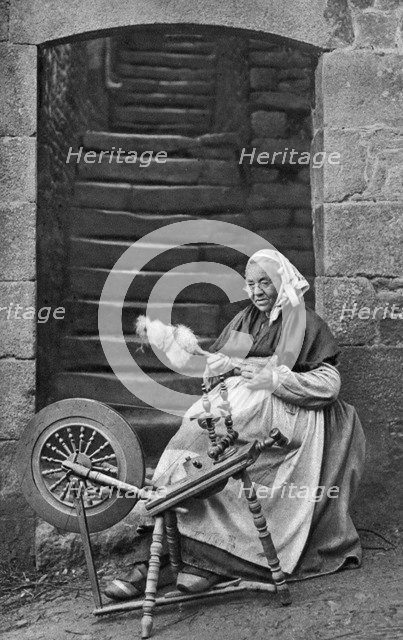 A woman at a spinning wheel, Dinan, Brittany, France, c1922. Artist: Unknown