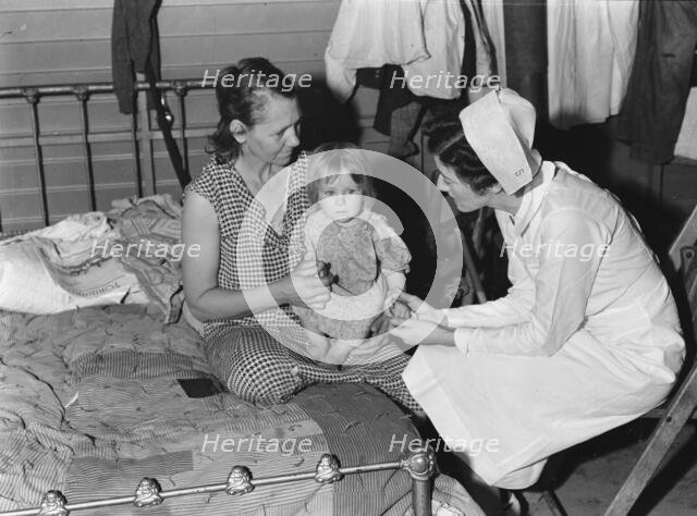 Nurse attending sick baby, FSA camp, Farmersville, Tulare County, California, 1939. Creator: Dorothea Lange.