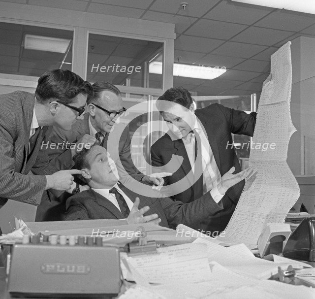 A salesman gets a helping hand in checking the figures, 1967.  Artist: Michael Walters