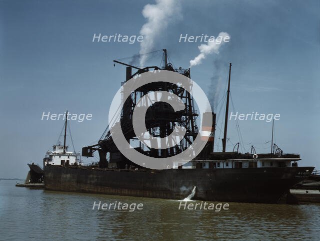 Loading coal into a freighter at one of the Pennsylvania Railroad docks, Sandusky, Ohio, 1943. Creator: Jack Delano.
