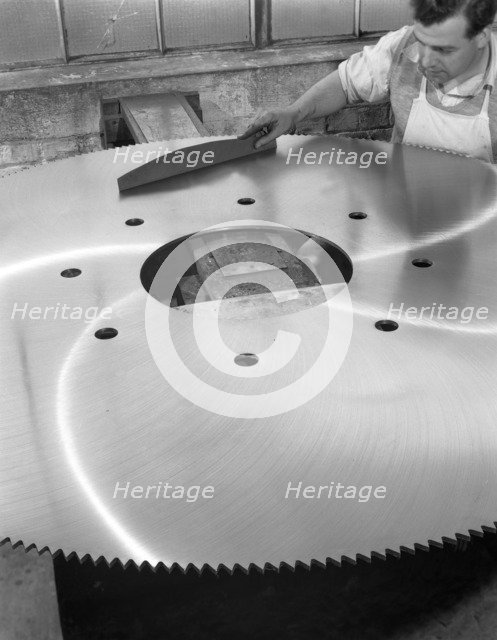 A machinist quality checking a six foot circular saw blade, Sheffield, South Yorkshire, 1963. Artist: Michael Walters