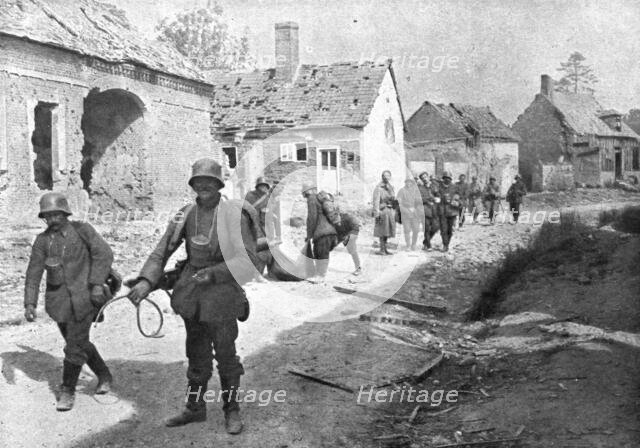 'A travers le champ de bataille; prisonniers allemands traversant un village reconquis..., 1918. Creator: Unknown.
