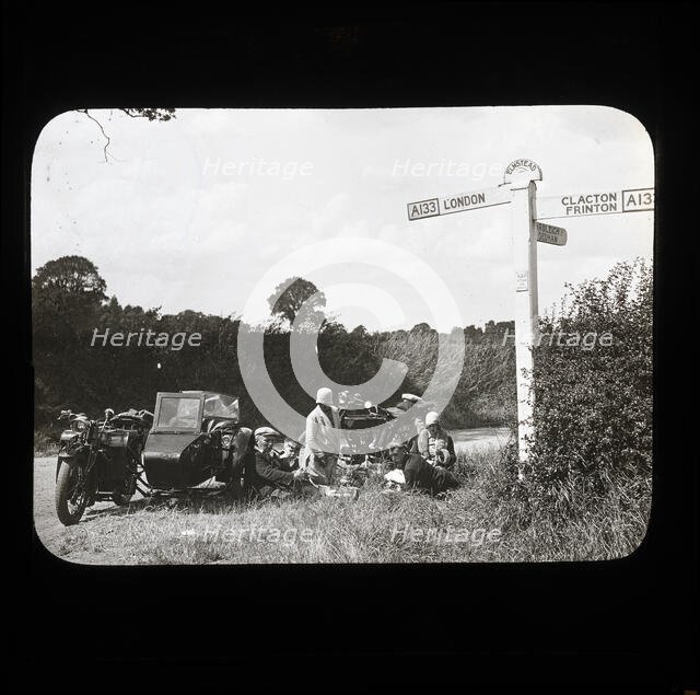 A group of people with two motorcycles and a sidecar having a picnic at the side of..., 1926-1939.  Creator: Norman Kingsley Harrison.