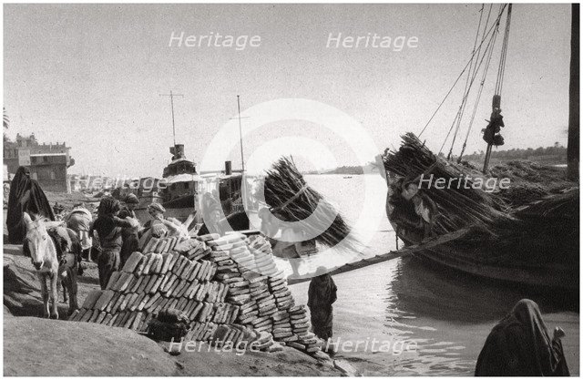 Unloading cargo from a boat, Muhaila, Baghdad, Iraq, 1925.Artist: A Kerim