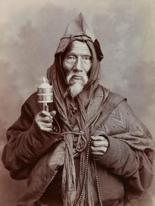 A bearded elderly man, carrying a prayer wheel and a rosary, in a studio setting, c1900. Creator: Thomas Parr.