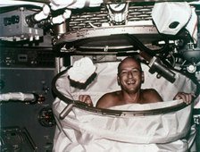 Conrad in shower facility aboard Skylab 2, 1973. Creator: NASA.
