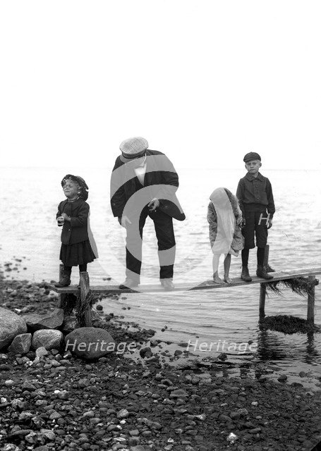 A man with three children on a jetty, Landskrona, Sweden, 1910. Artist: Unknown