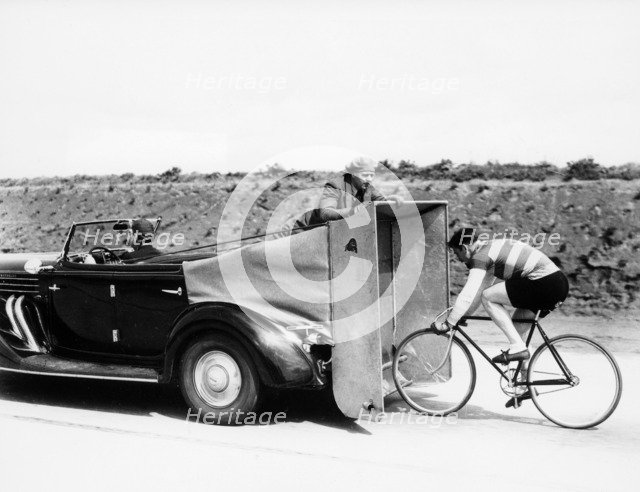 Cyclist training behind an Auburn car, c1935. Artist: Unknown