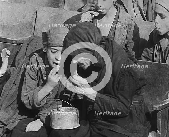 Italian Civilians Eating Food in a Bomb-Damaged Italian Town, 1943-1944. Creator: British Pathe Ltd.