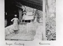 Woman stands in a sugar crushing mill, Dominica, 1897. Artist: Unknown