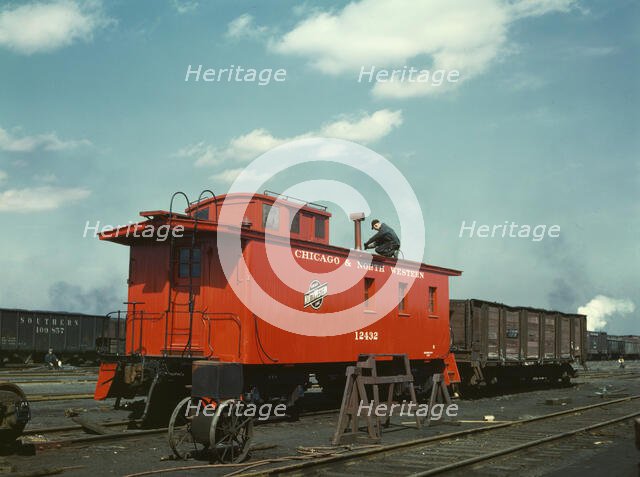 C & NW RR putting the finishing touches on a rebuilt caboose..., Proviso yard, Chicago, Ill., 1943. Creator: Jack Delano.