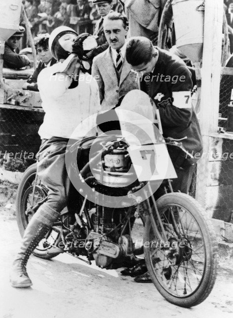 Van Horne taking a drink whilst on his Norton bike. Artist: Unknown