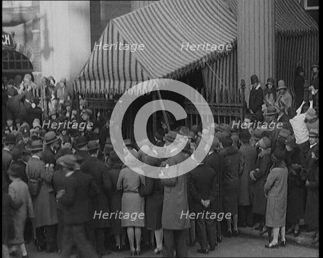 A Crowd of Civilians Gathering Under a Canopy Wearing Smart Outfits and Hats, 1920. Creator: British Pathe Ltd.