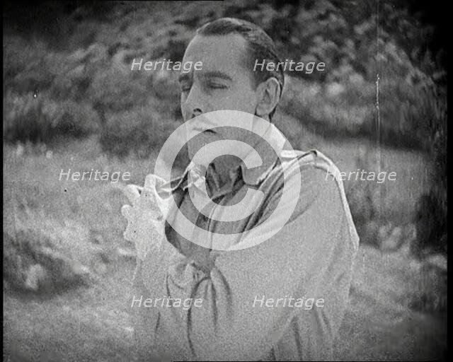 Scene from the Feature Film 'The White Sheik'. An Actor Portraying a Male Soldier Grabbing..., 1920s Creator: British Pathe Ltd.