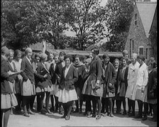 A Group of Young Female Civilians Wearing School Uniforms Standing in Front of a School, 1920. Creator: British Pathe Ltd.