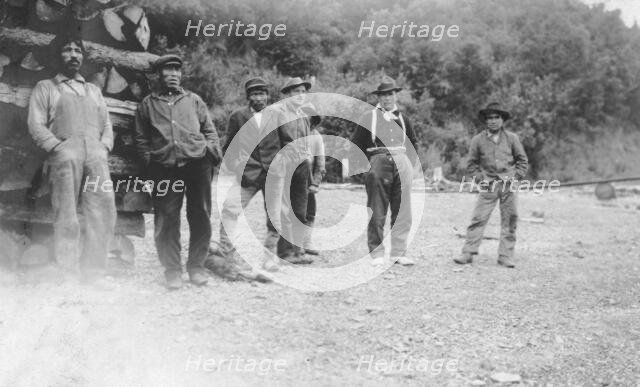 Men next to logs, between c1900 and 1916. Creator: Unknown.