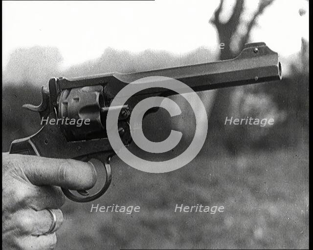 Scene from the Feature Film 'The White Sheik'. A Pistol Being Held By a Man With His Finger...,1920s Creator: British Pathe Ltd.