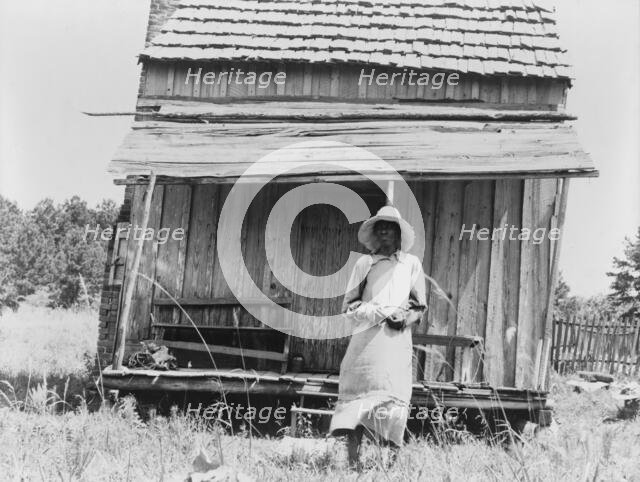 Sharecropper's cabin and sharecropper's wife, Ten miles south of Jackson, Mississippi, 1937. Creator: Dorothea Lange.