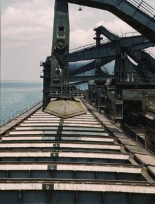 Pennsylvania R.R. iron ore docks, unloading ore from a lake freighter...ore unloaders, 1943. Creator: Jack Delano.
