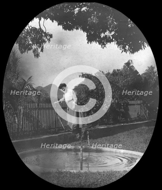 Woman by a pond in a garden, Rio de Janeiro, Brazil, late 19th or early 20th century. Artist: Unknown
