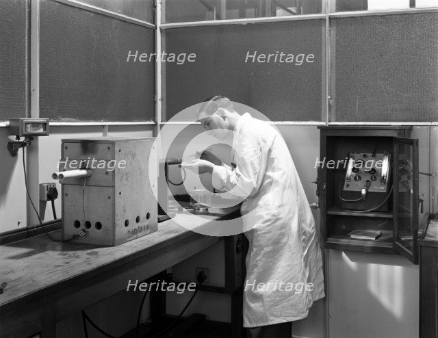 Lab tachnician using a table top test furnace, Sheffield, South Yorkshire, 1962. Artist: Michael Walters