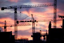 A building site at sunset with cranes silhouetted against a red sky, 2007. Artist: Historic England Staff Photographer.