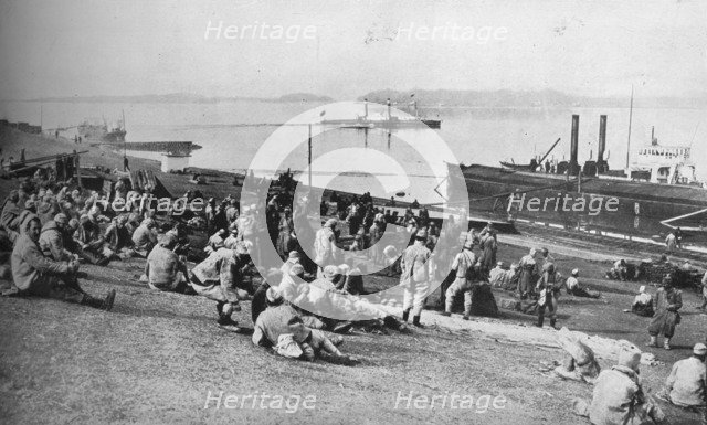 ''Austrian prisoners taken by Serbians resting at mid-day on the banks of the Danube', 1915.  Artist: Unknown.