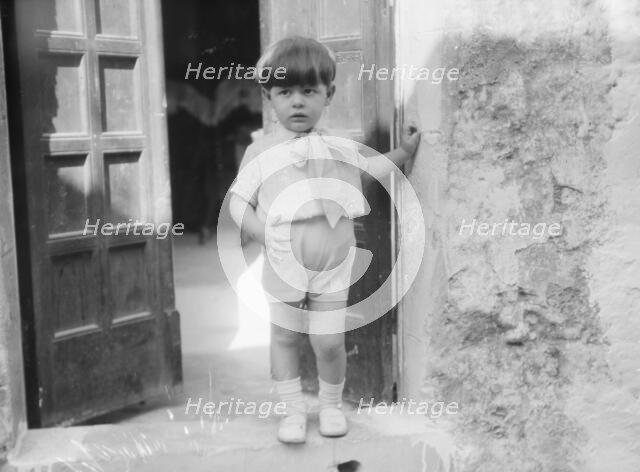 Cenerini, Mr., child of, standing in a doorway, 1929 Creator: Arnold Genthe.