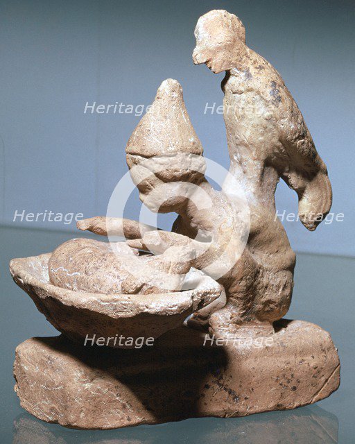 Greek terracotta of a haruspex inspecting pig's entrails. Artist: Unknown