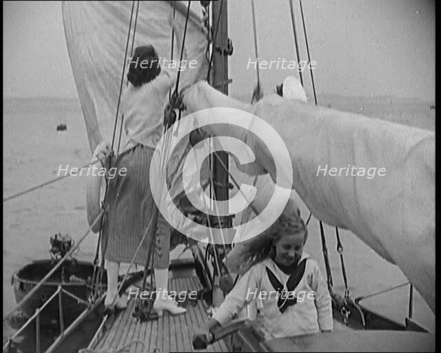 Female Civilians Wearing Summer Outfits and a Captain's Hat Onboard of a Boat Hoisting up a..., 1920 Creator: British Pathe Ltd.