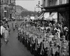 Crowd Watching German Soldiers Marching Down a Street Away from the Camera, 1930s. Creator: British Pathe Ltd.