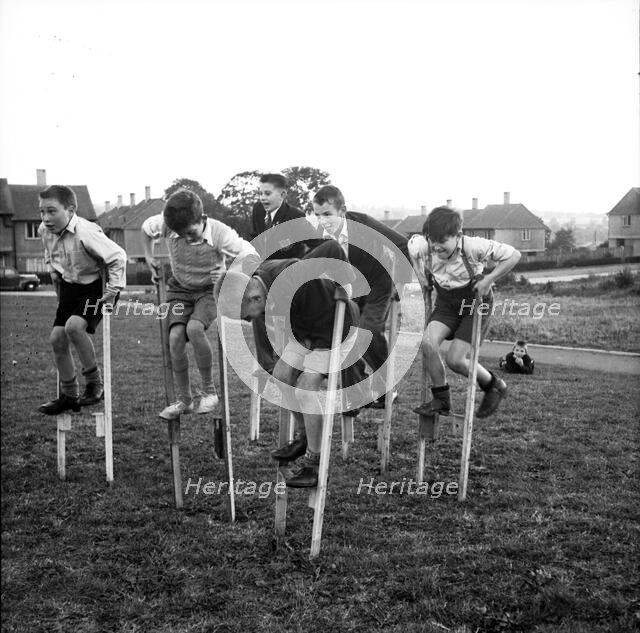 Children walking on stilts, c1955. Creator: Arthur Charles Kirby Ware.