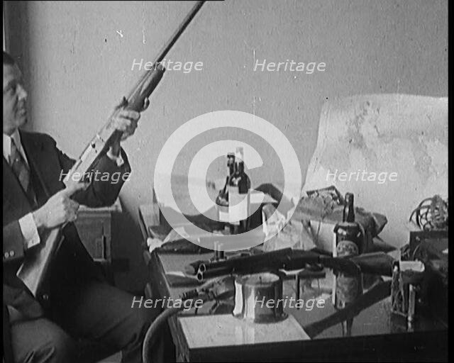 Male Detective Showing off Smugglers' Captured Guns, 1929.  Creator: British Pathe Ltd.