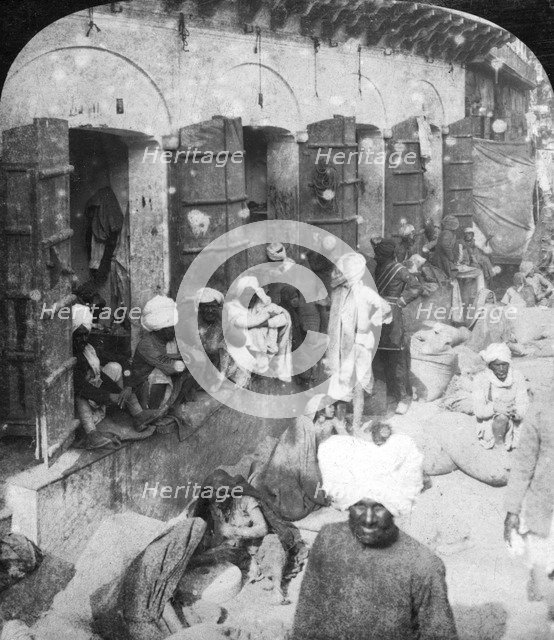 Indian women grinding corn between two round stones, Delhi, India, 1900s.Artist: Rose Stereographs