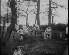 Young Female Civilians Wearing Sport Outfits Running Across a Field Jumping over Water in a..., 1920 Creator: British Pathe Ltd.