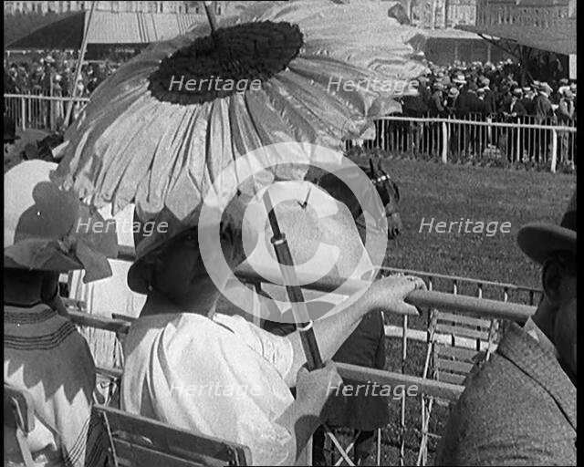 A Female Civilian Emerging from Behind a Sun Flower Shaped Parasol, 1920. Creator: British Pathe Ltd.