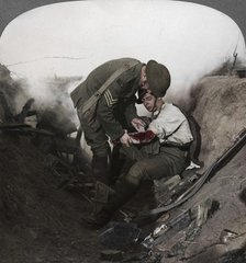 Soldier receiving first aid from a sergeant in a sap, Battle of Peronne, World War I, 1914-1918. Artist: Realistic Travels Publishers.