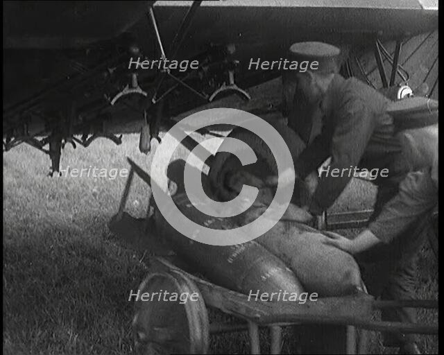 Male British Officers Loading Bombs Onto a Plane, 1920s Creator: British Pathe Ltd.